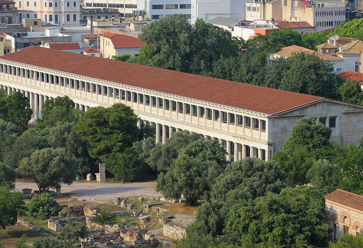 Two-story colonnade of the reconstructed Stoa of Attalos with red tiled roof amid trees of the Ancient Agora