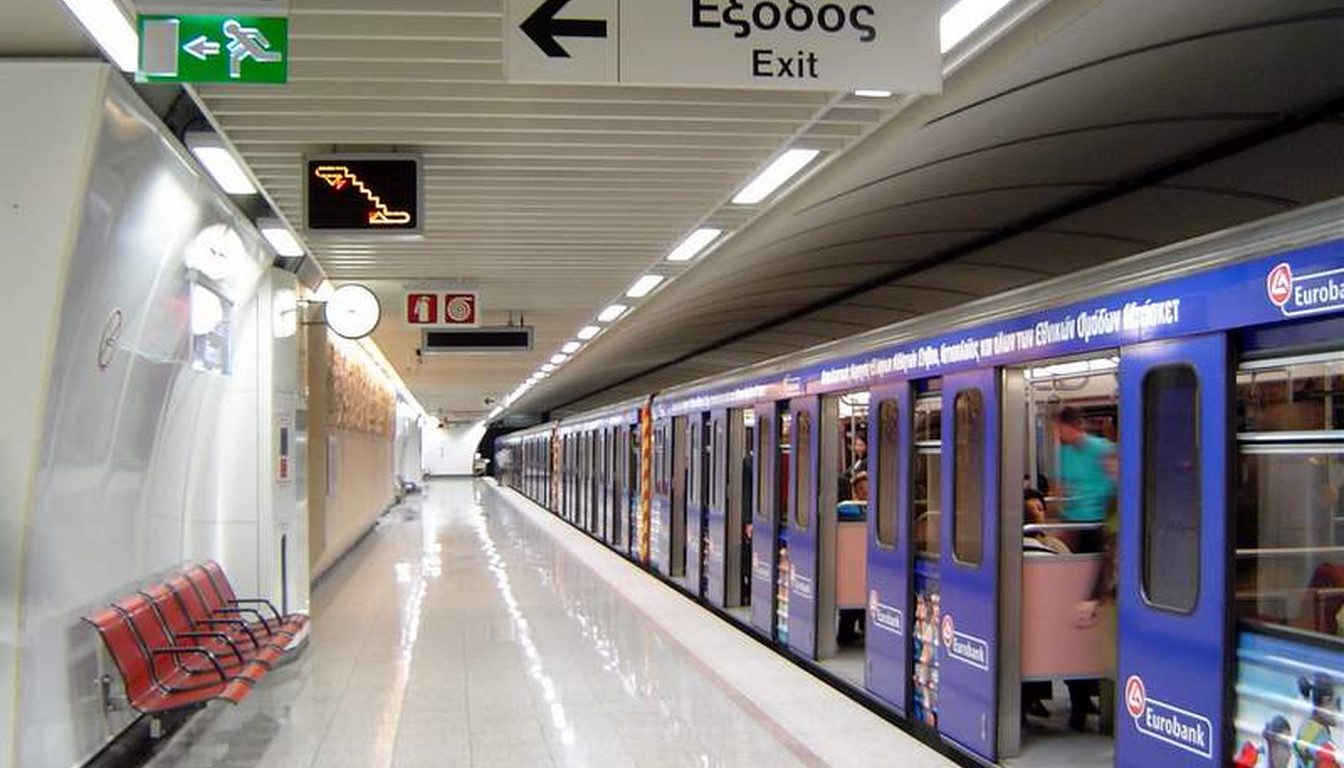 Athens Metro train wrapped in advertising at Acropolis station platform with bilingual Greek and English exit sign
