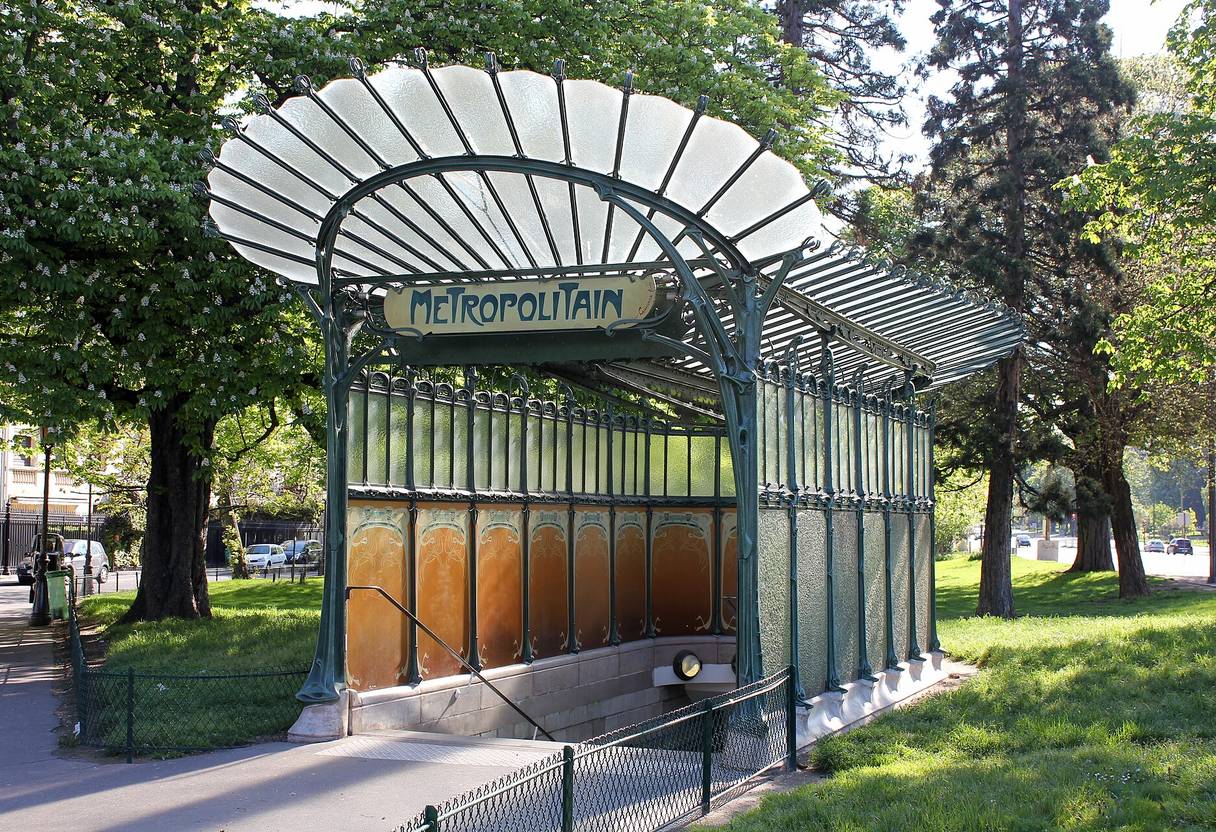 Guimard Art Nouveau édicule at Porte Dauphine with glass fan canopy, green ironwork and orange panels among trees