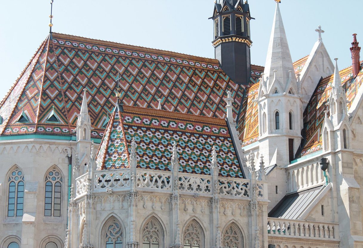 Diamond-patterned tiled roofs, white Gothic pinnacles and dark turret of Matthias Church in Budapest