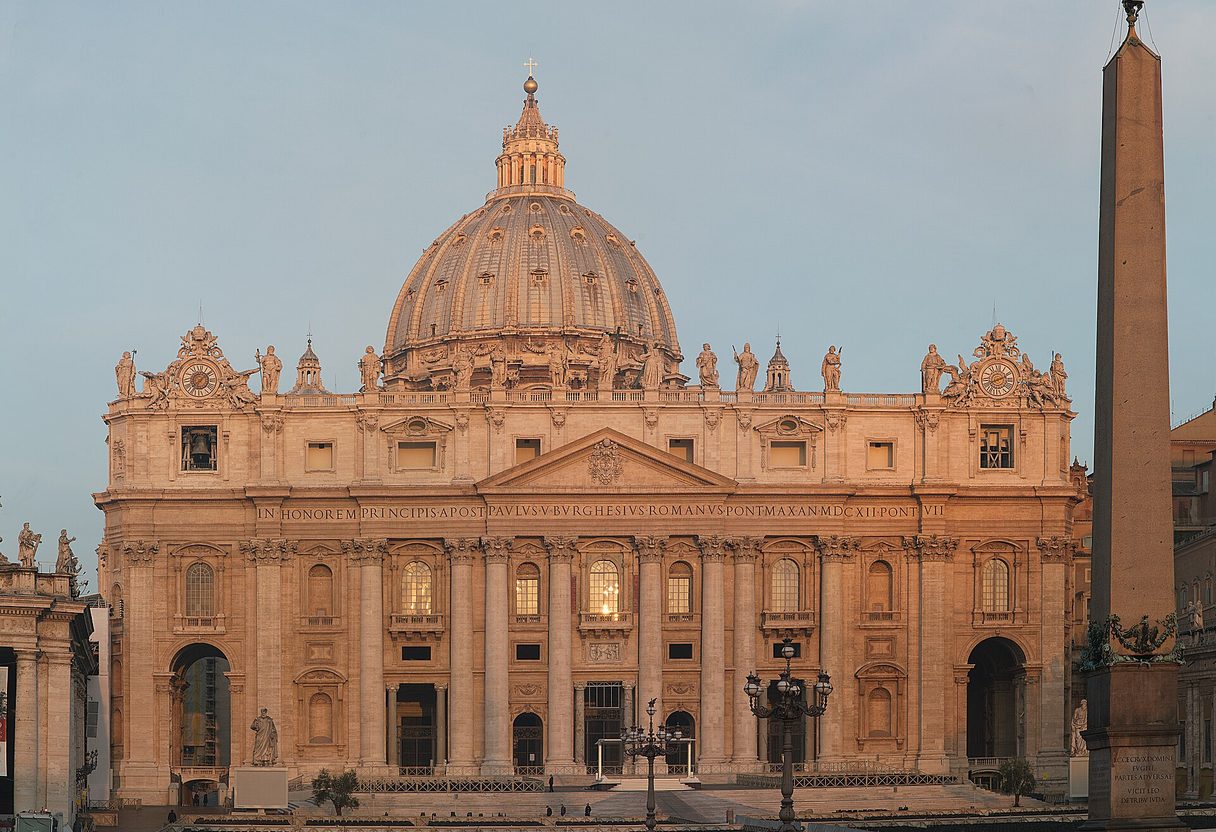 Facade and dome of St. Peter's Basilica glowing in morning light, with the obelisk of St. Peter's Square at right