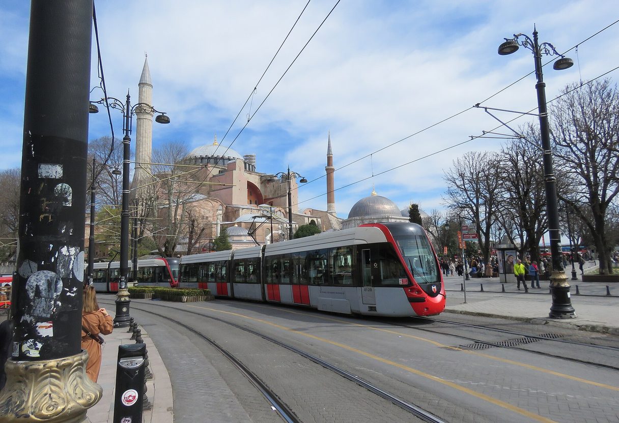 Modern T1 tram running along tracks in Sultanahmet with Hagia Sophia and its minarets in the background