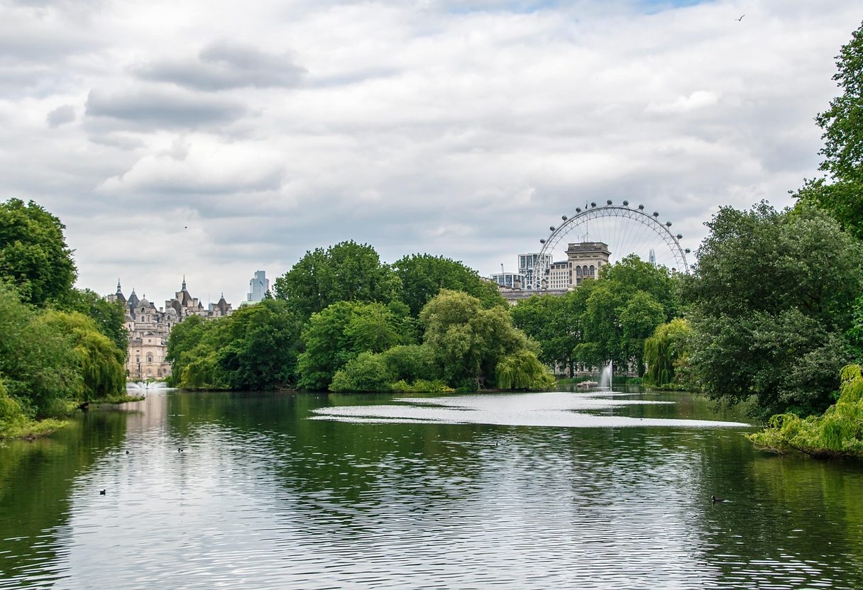 St James's Park lake framed by trees, with Horse Guards turrets and the London Eye rising above the greenery