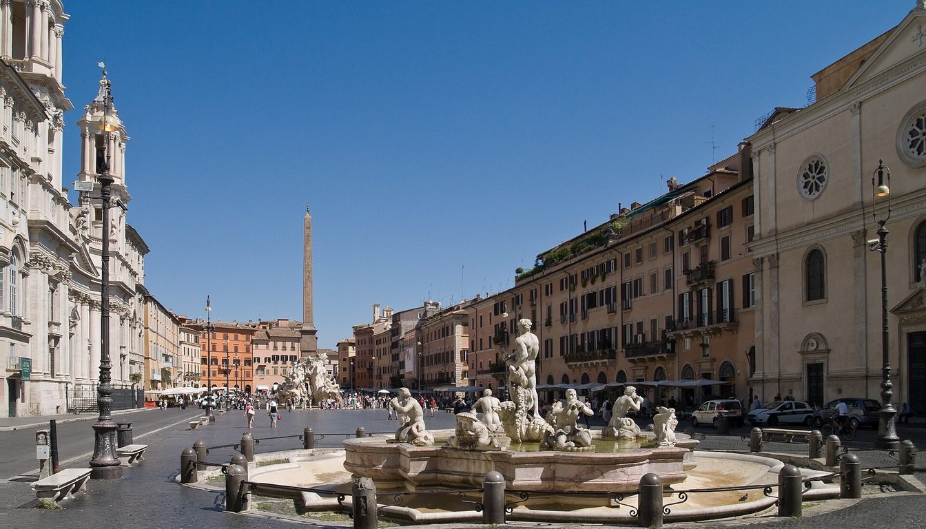 Piazza Navona under blue sky with the Fontana del Moro, the obelisk of the Four Rivers fountain and Sant'Agnese in Agone