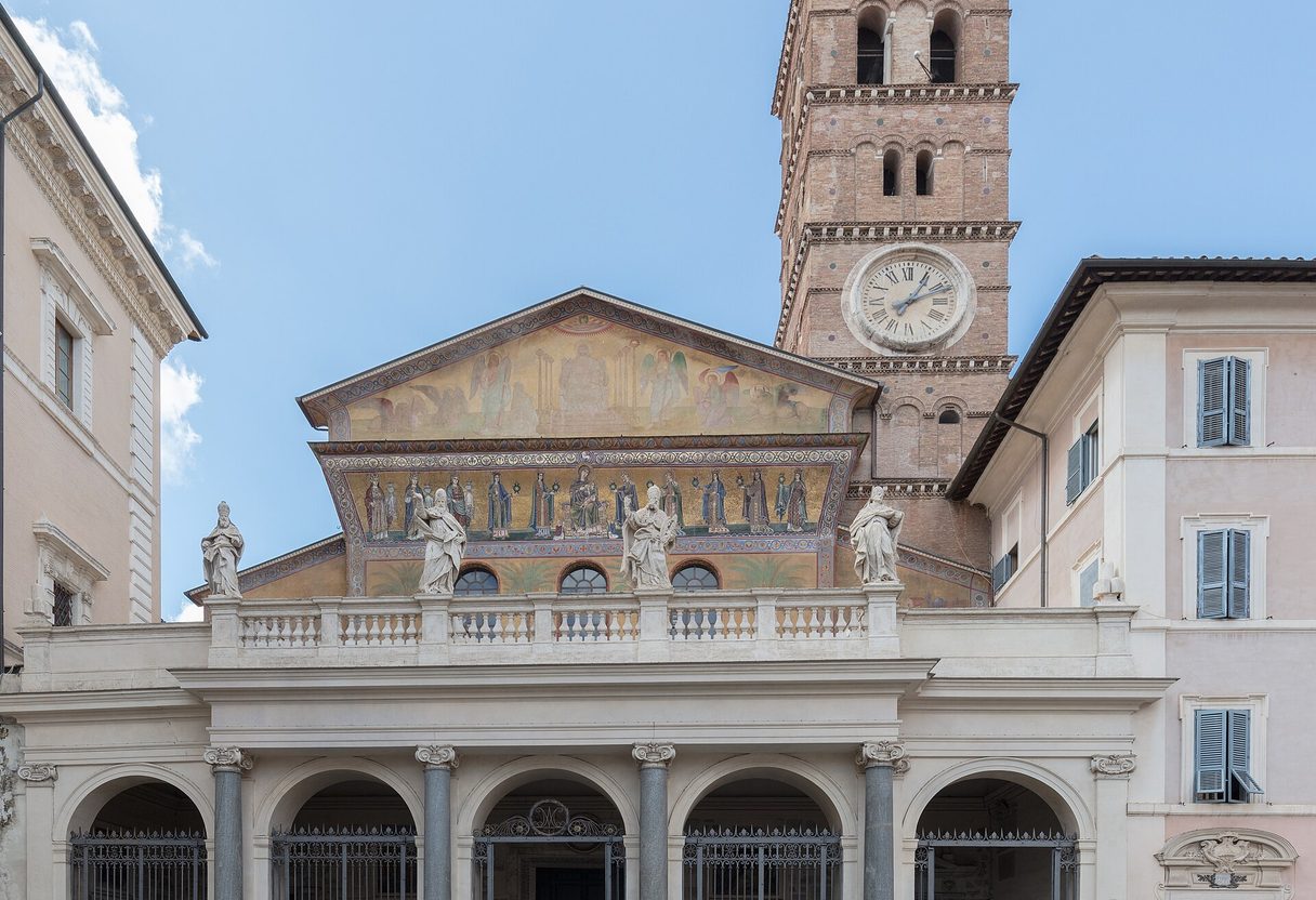 Facade of Santa Maria in Trastevere with golden mosaics, statues on the portico and Romanesque bell tower with clock